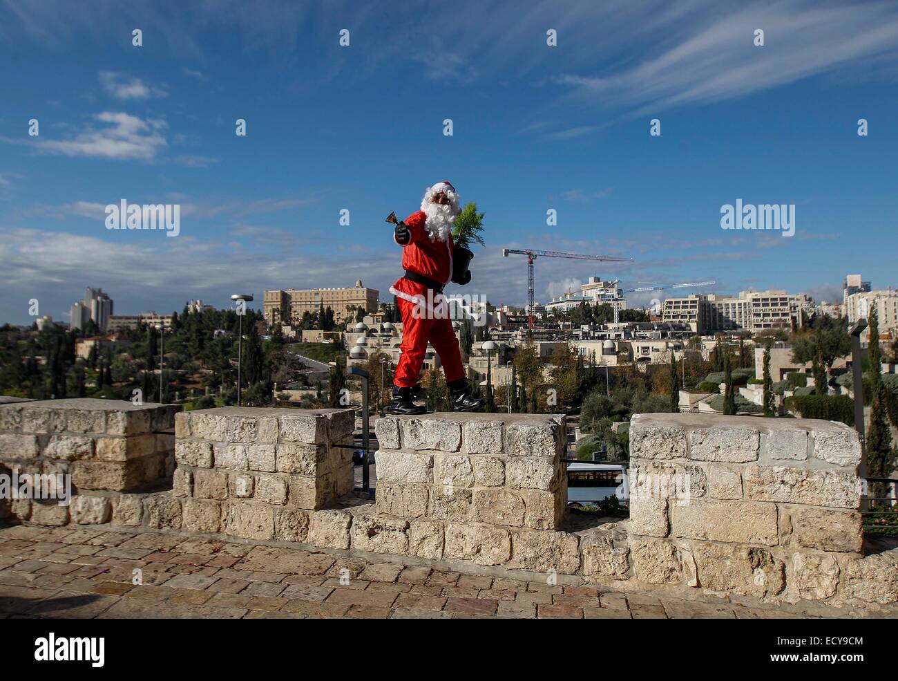 Jerusalem. 22nd Dec, 2014. Palestinian Issa Kassissieh dressed as Santa Claus stands on the wall of the Old City in Jerusalem, ahead of Christmas, on Dec. 22, 2014. Credit:  Muammar Awad/Xinhua/Alamy Live News Stock Photo