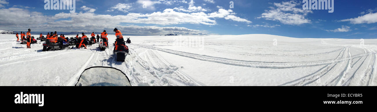 Panoramic view of people on snow mobiles in snowy landscape - Smartphone Captured Stock Image