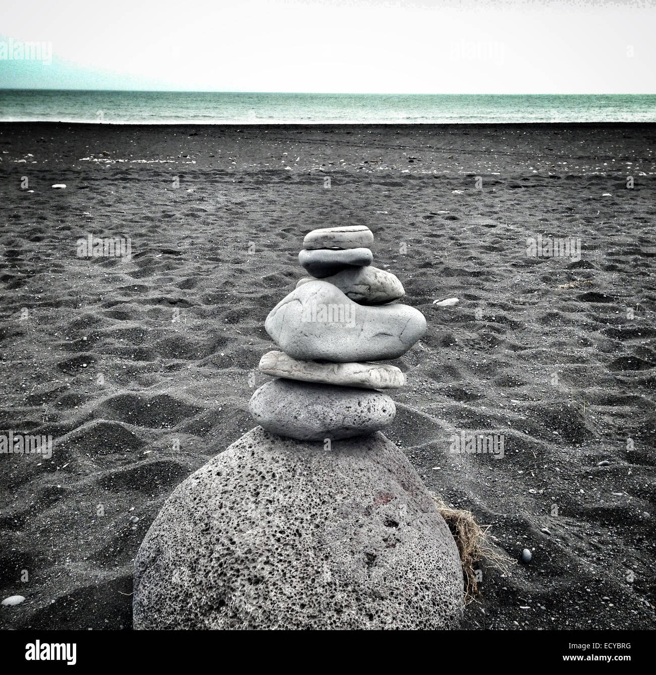 Stacked stones on black sandy beach - Smartphone Captured Stock Image
