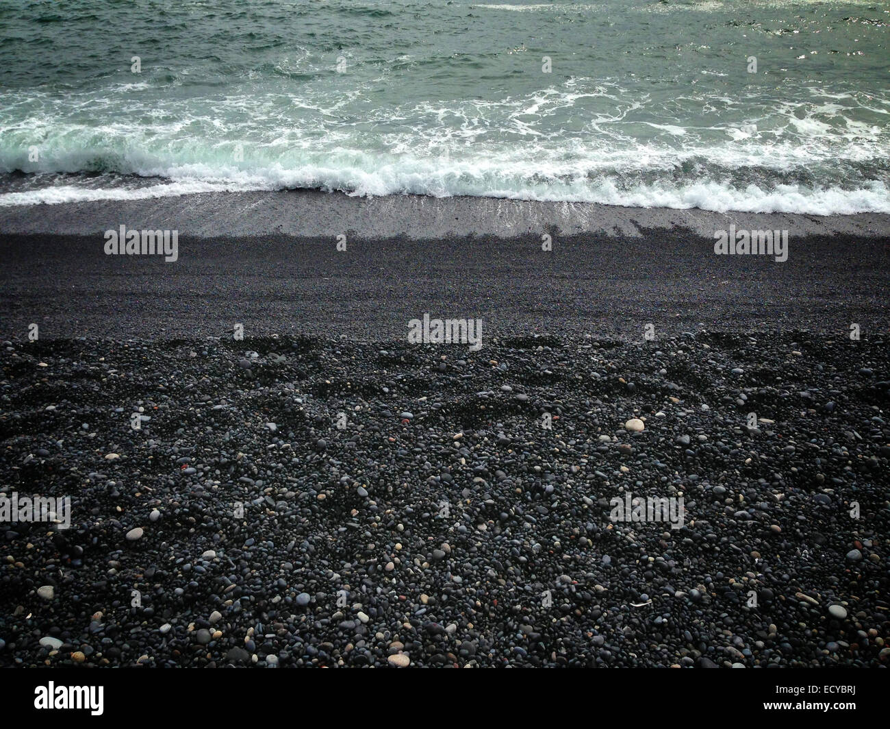Waves washing up on black sandy beach - Smartphone Captured Stock Image