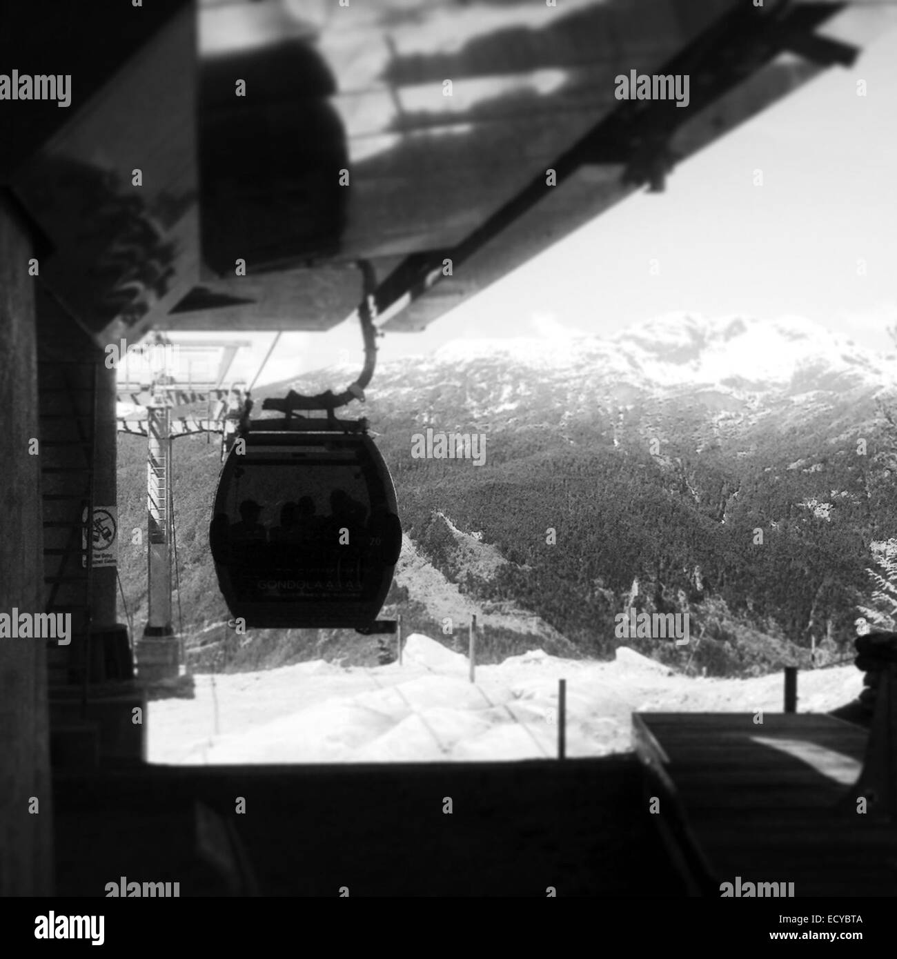 Gondola hanging from lift machinery in snowy landscape - Smartphone Captured Stock Image