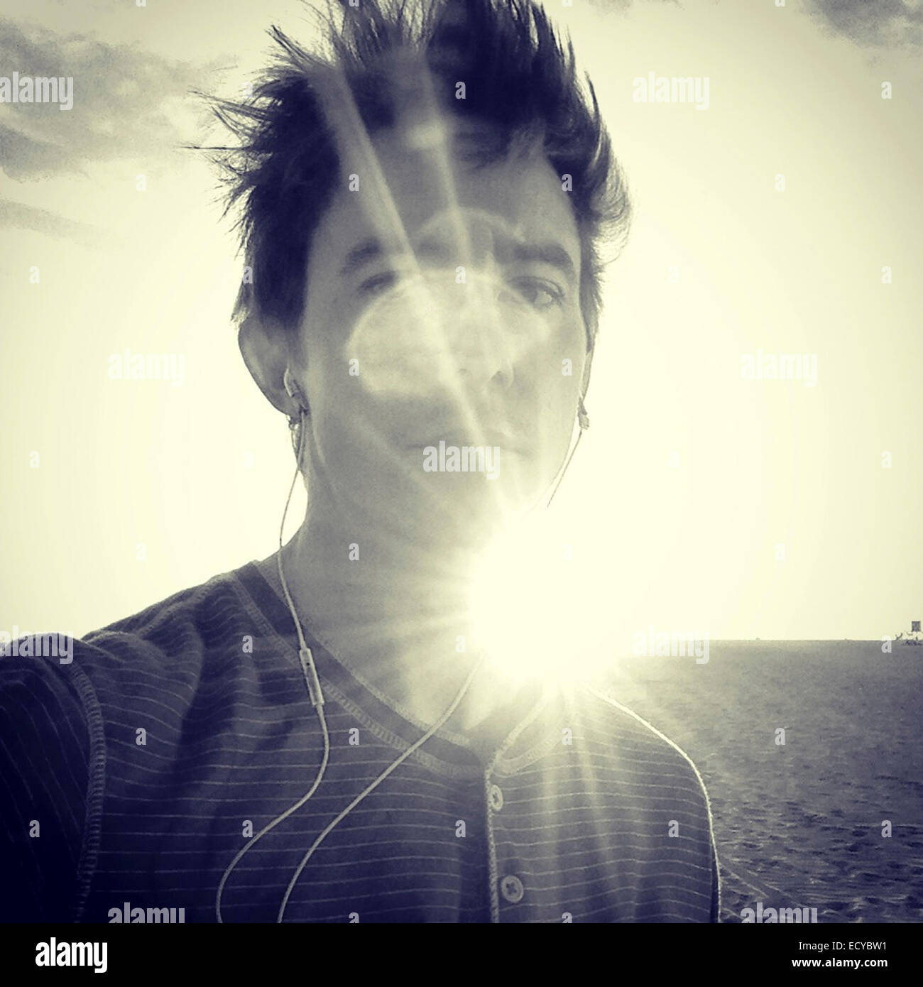 Caucasian man standing in sunbeams - Smartphone Captured Stock Image