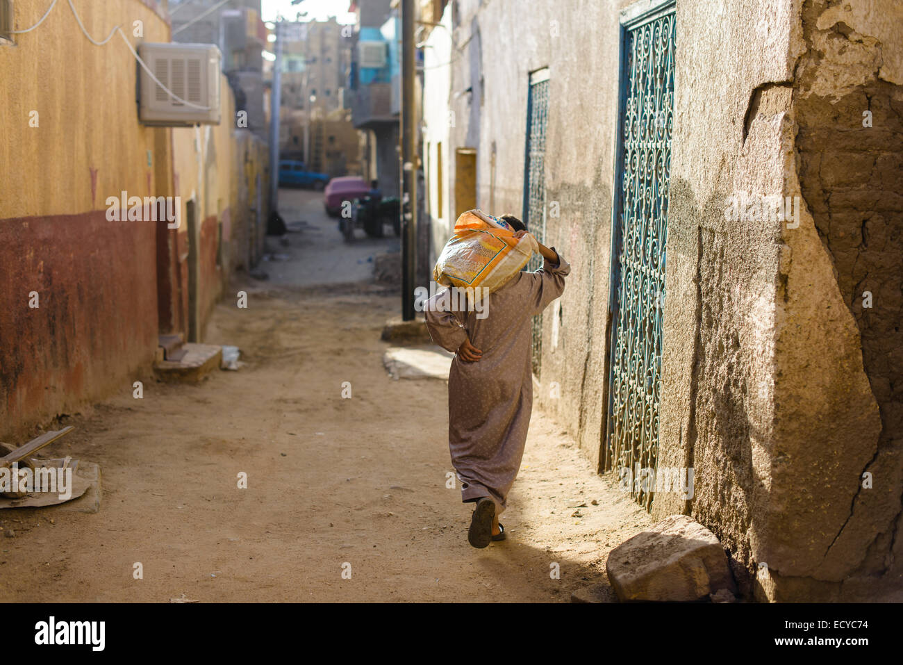 Man carrying sack on the streets of Aswan, Egypt Stock Photo