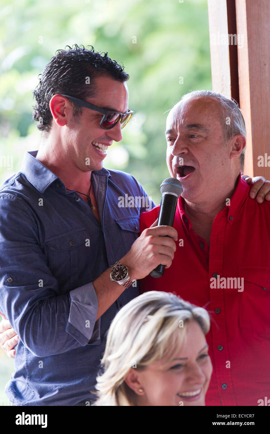 Grandfather and grandson talking into microphone at family reunion Stock Photo