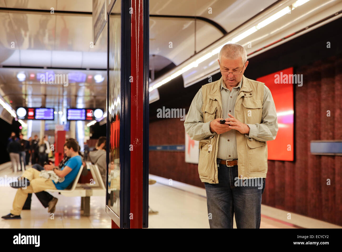 old white male checking using cell phone inside metro station germany europe Stock Photo