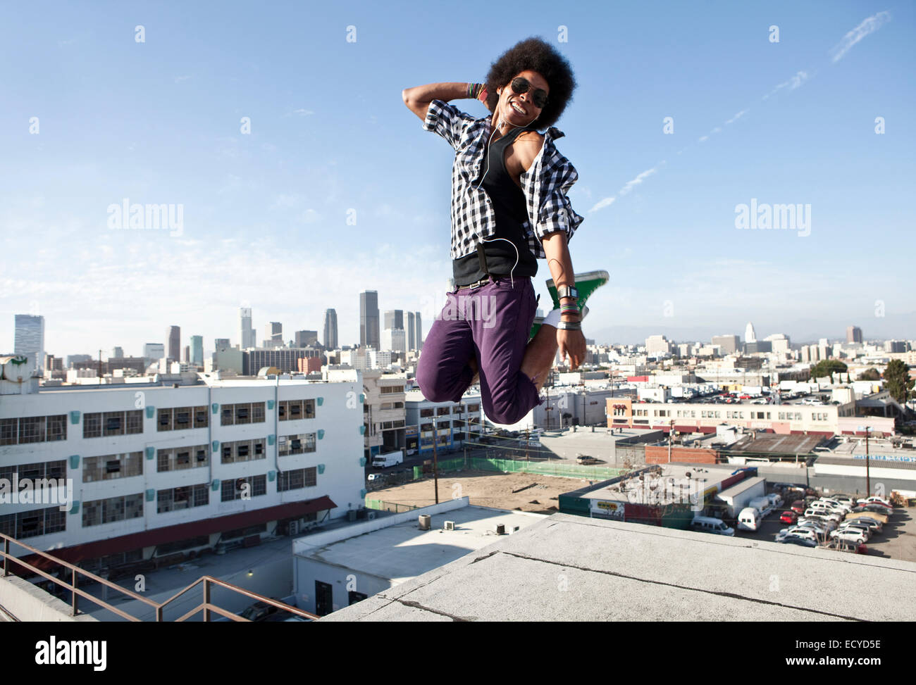 African American man jumping for joy on urban rooftop Stock Photo