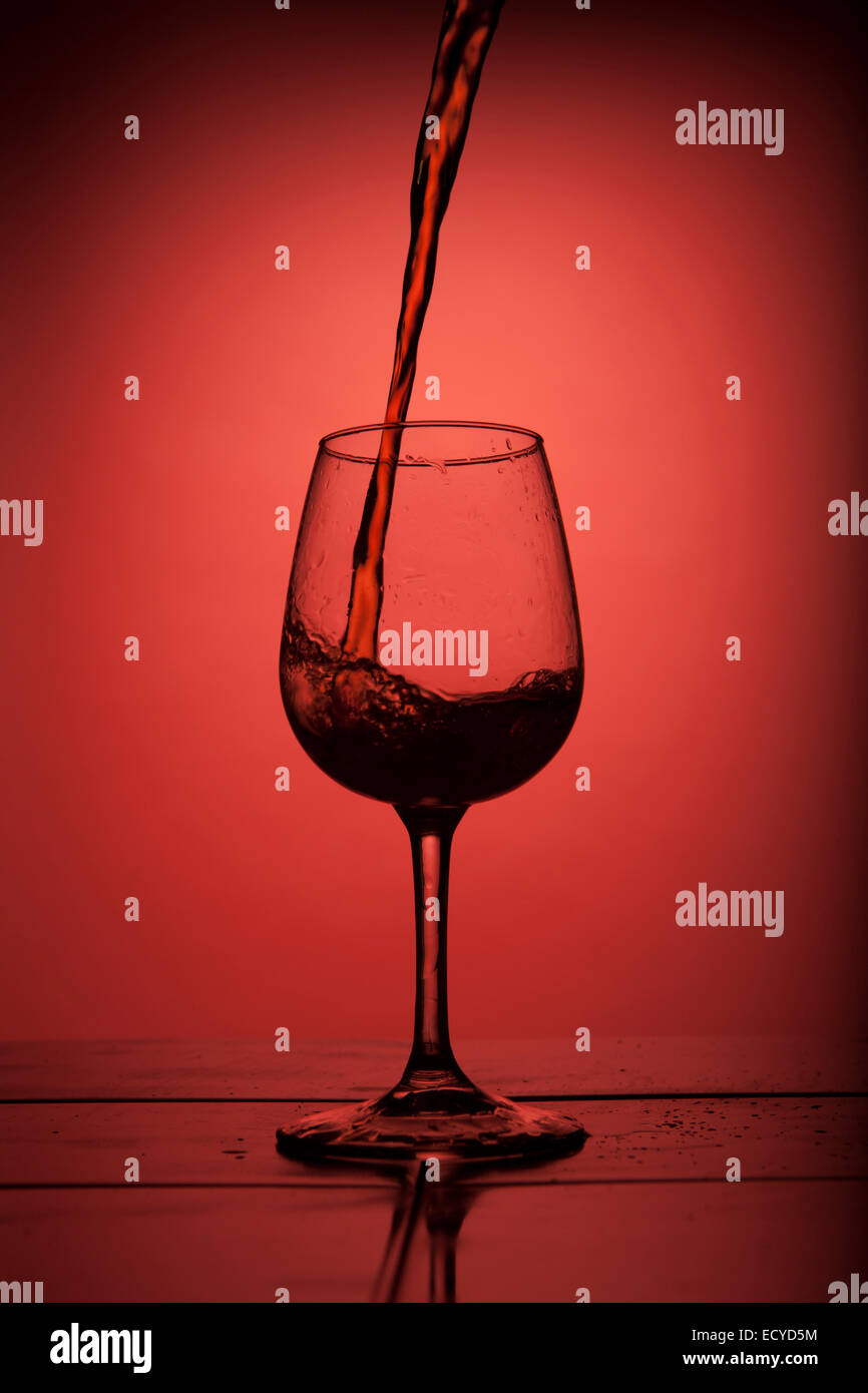 Red wine pouring into wine glass Stock Photo