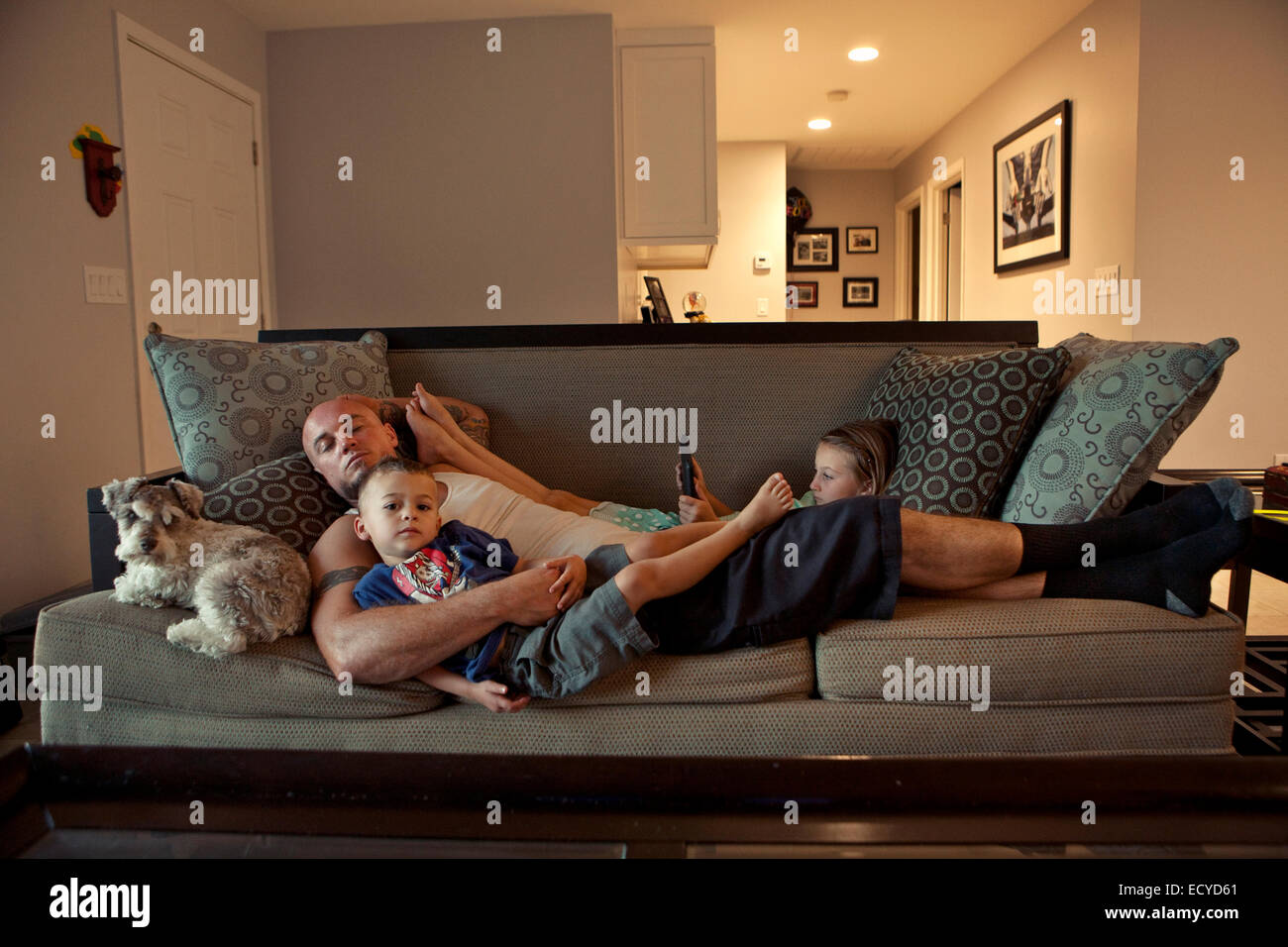 Caucasian father and children relaxing on sofa Stock Photo