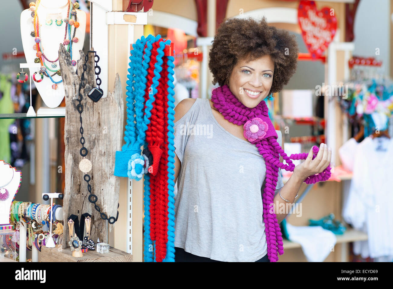 Mixed race woman trying on necklaces in store Stock Photo