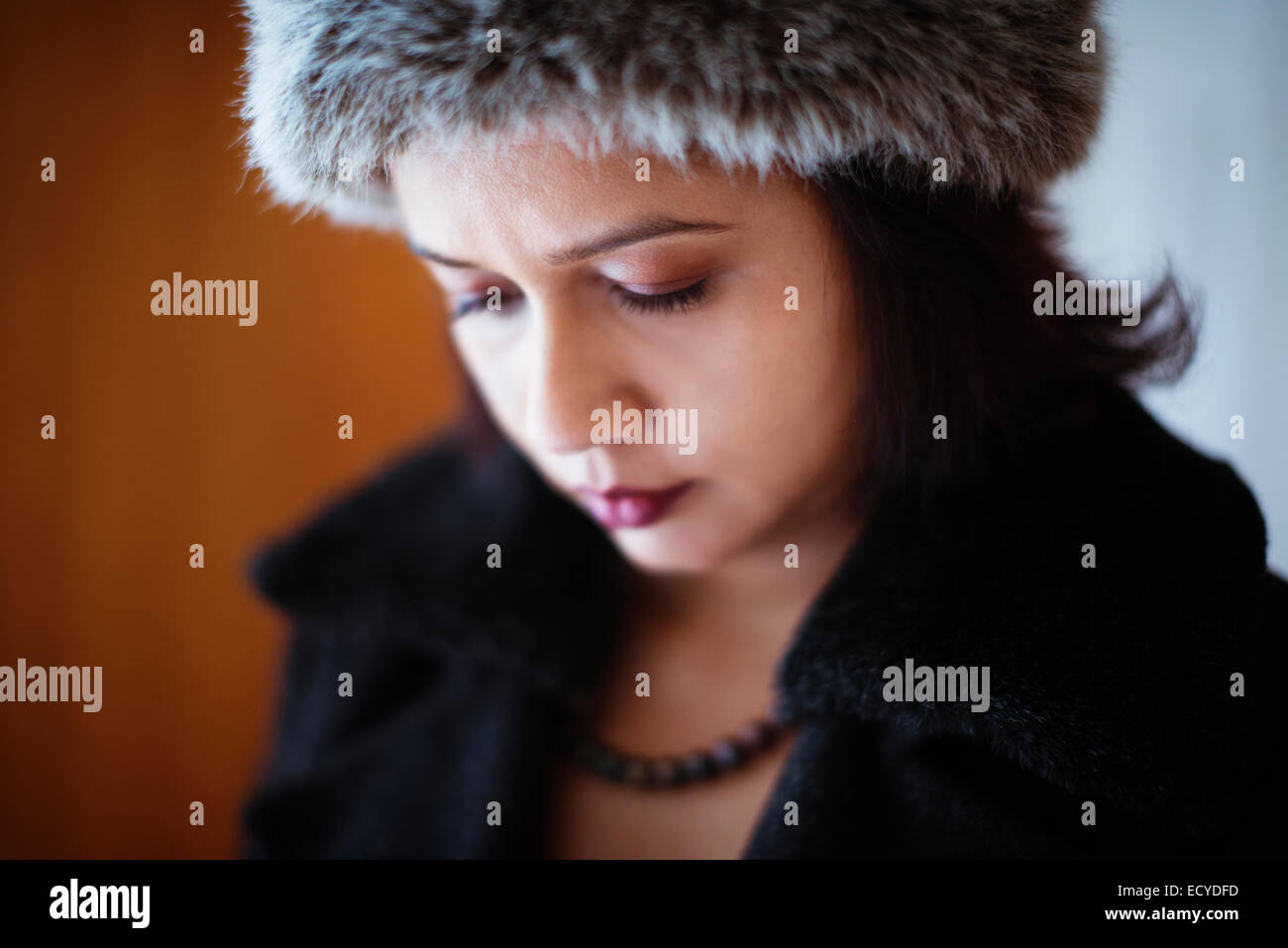 Mixed race woman wearing furry hat and coat Stock Photo