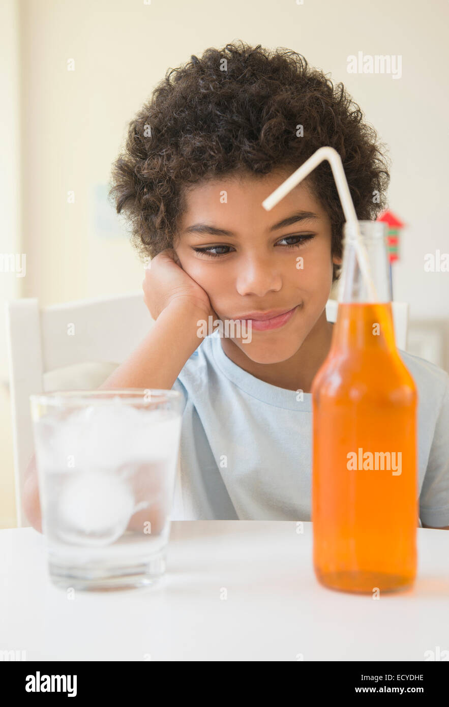 Mixed race boy choosing between soda and water Stock Photo