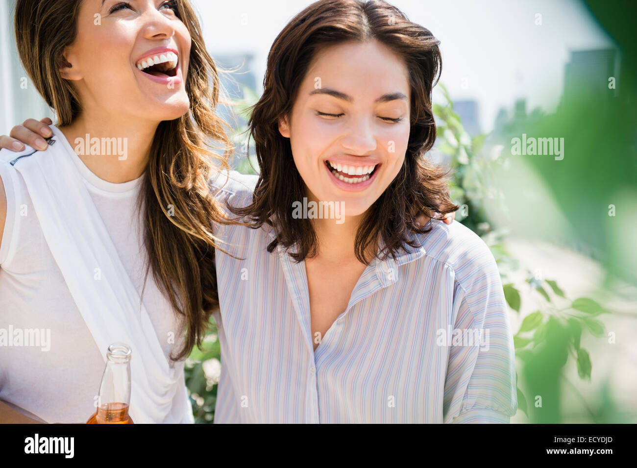 Hispanic women laughing outdoors Stock Photo