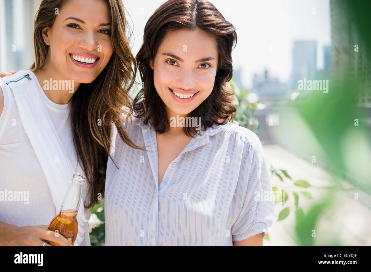 Hispanic women relaxing together outdoors Stock Photo