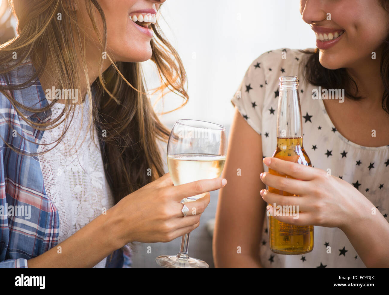 Hispanic women drinking beer and wine together Stock Photo