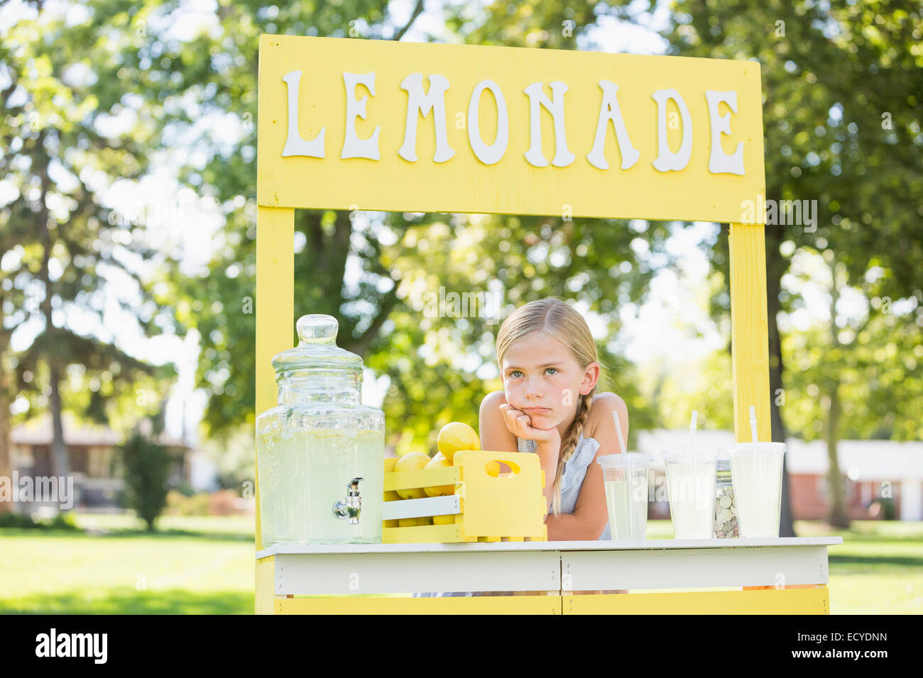Bored Caucasian girl at lemonade stand Stock Photo