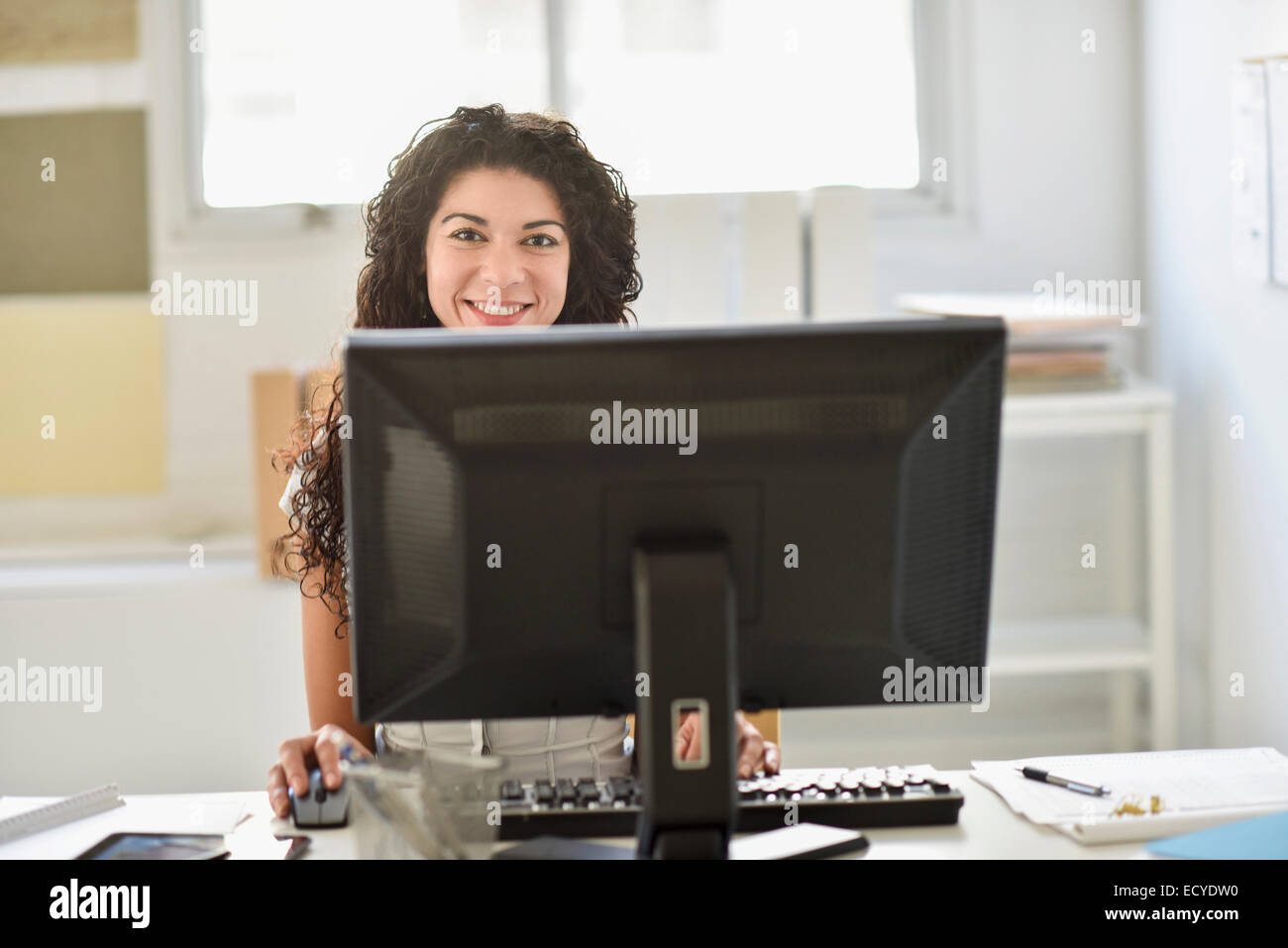 Mixed race businesswoman working on computer at desk in office Stock Photo