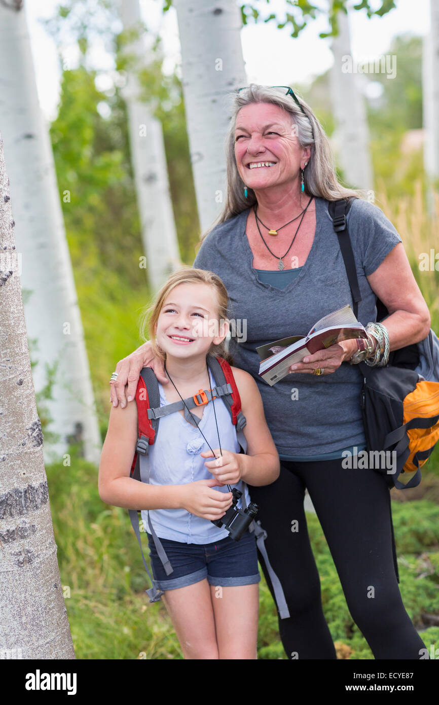 Caucasian grandmother and granddaughter hiking in forest Stock Photo