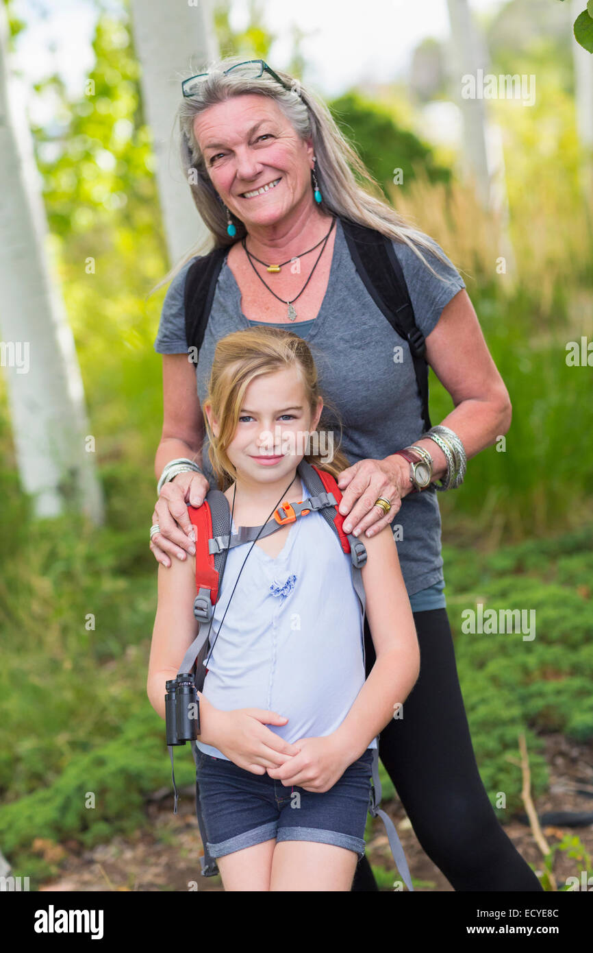 Caucasian grandmother and granddaughter smiling in forest Stock Photo