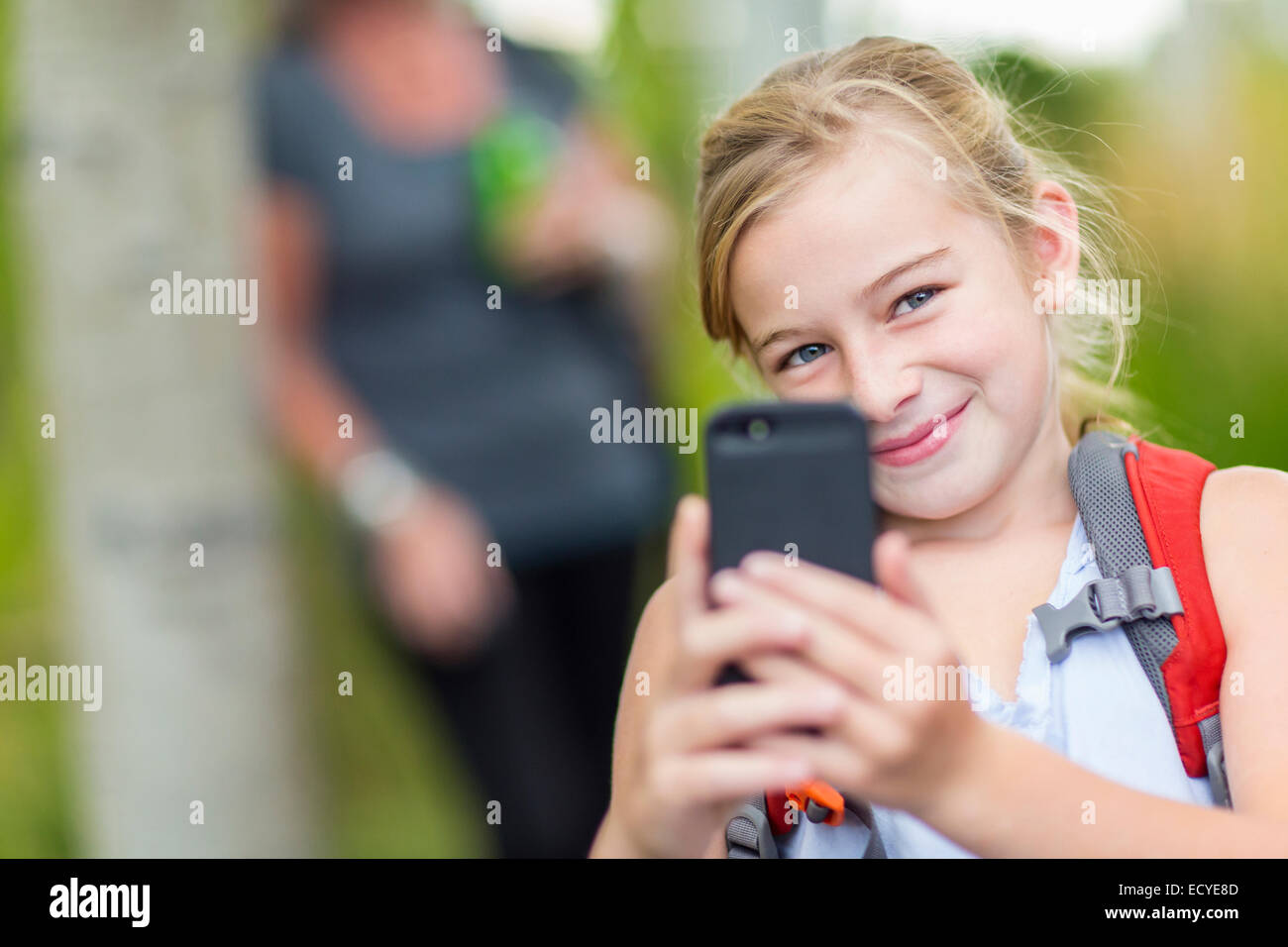 Caucasian girl taking cell phone photograph in forest Stock Photo