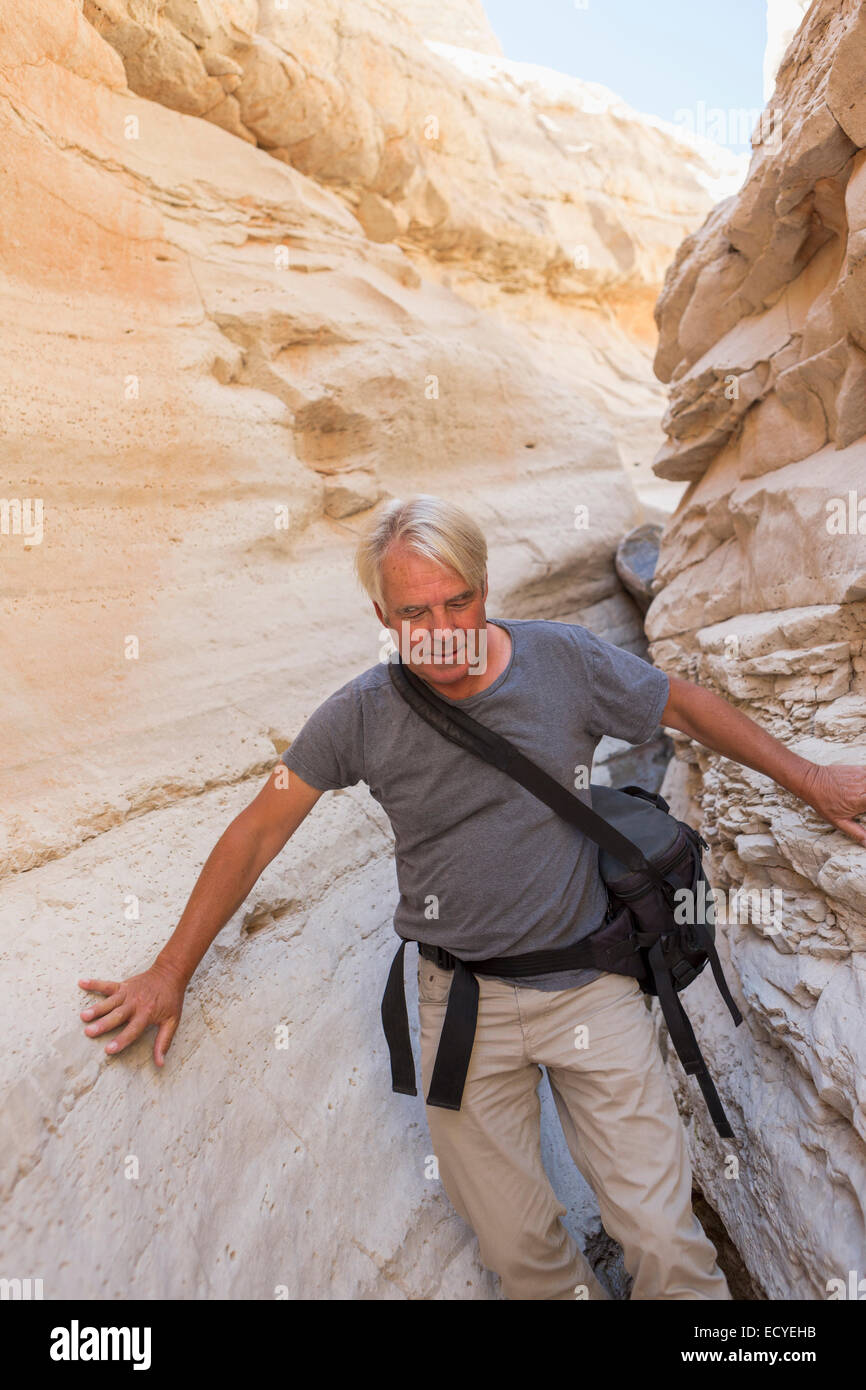 Older Caucasian man exploring rock formations Stock Photo