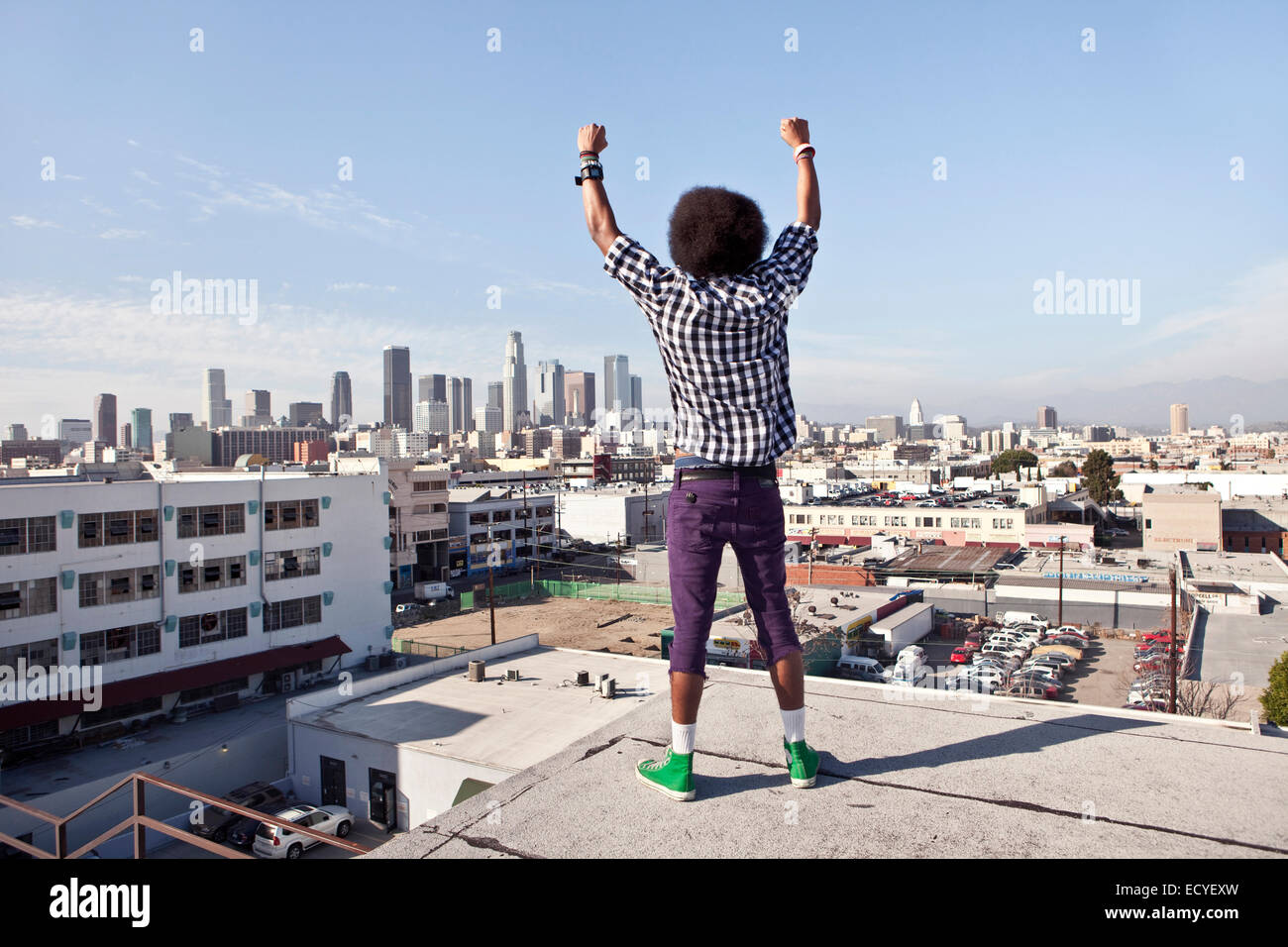 African American man overlooking cityscape from urban rooftop Stock Photo