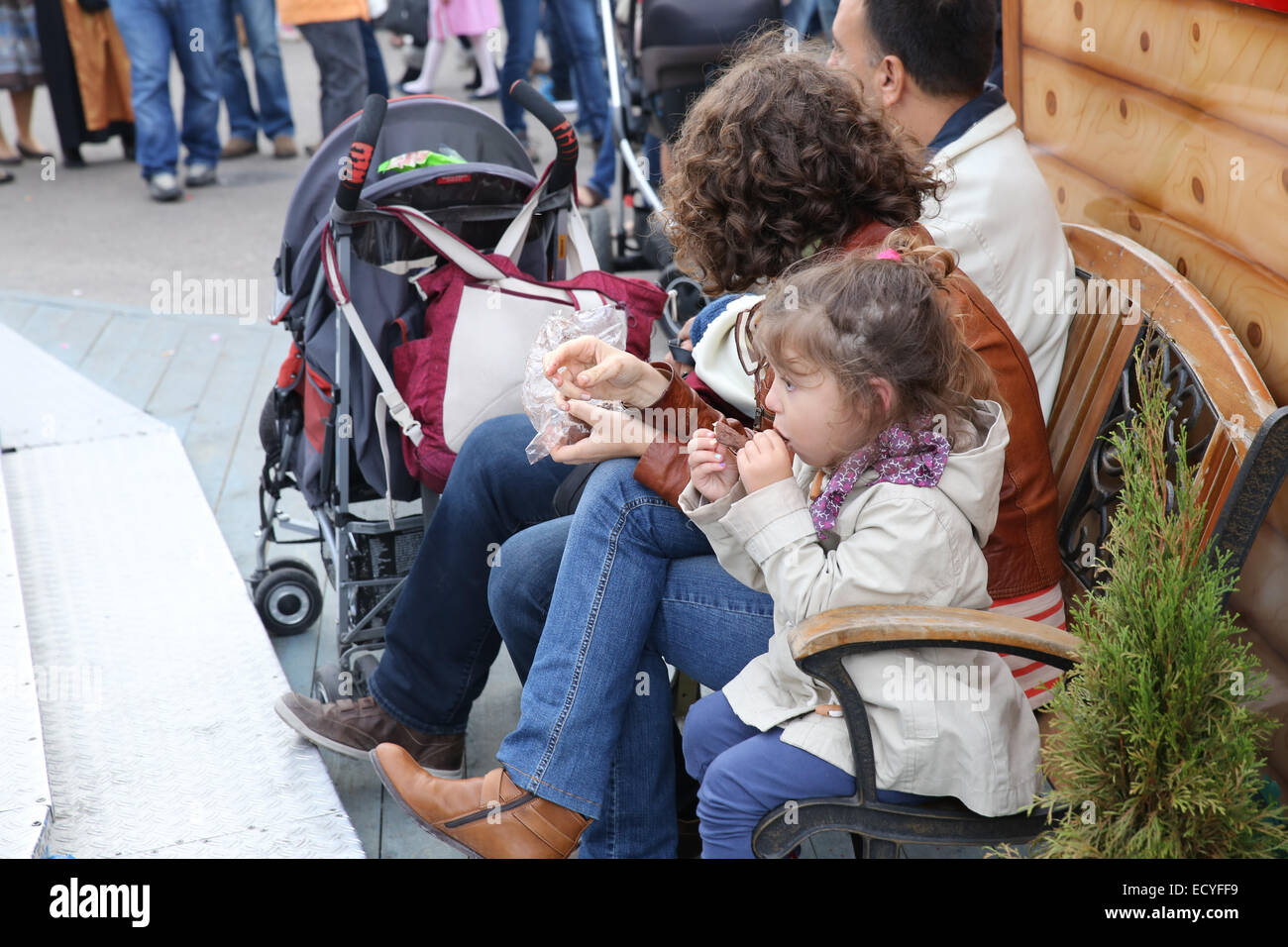 young girl eating snack sitting bench outdoor oktoberfest festival germany Stock Photo