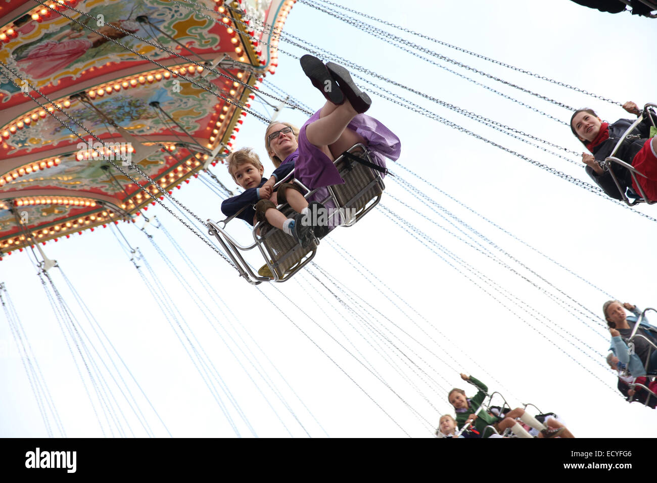 mother son ride flying chair oktoberfest amusement park Stock Photo