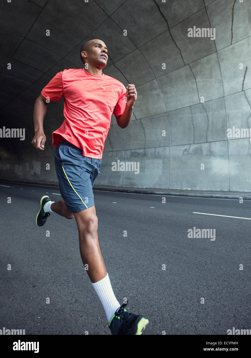 Black man running in urban tunnel Stock Photo Alamy