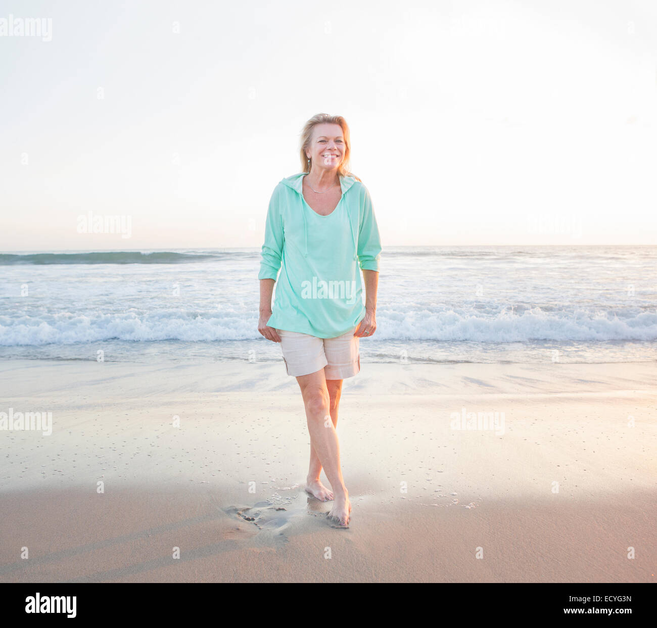 Caucasian woman smiling on beach Stock Photo