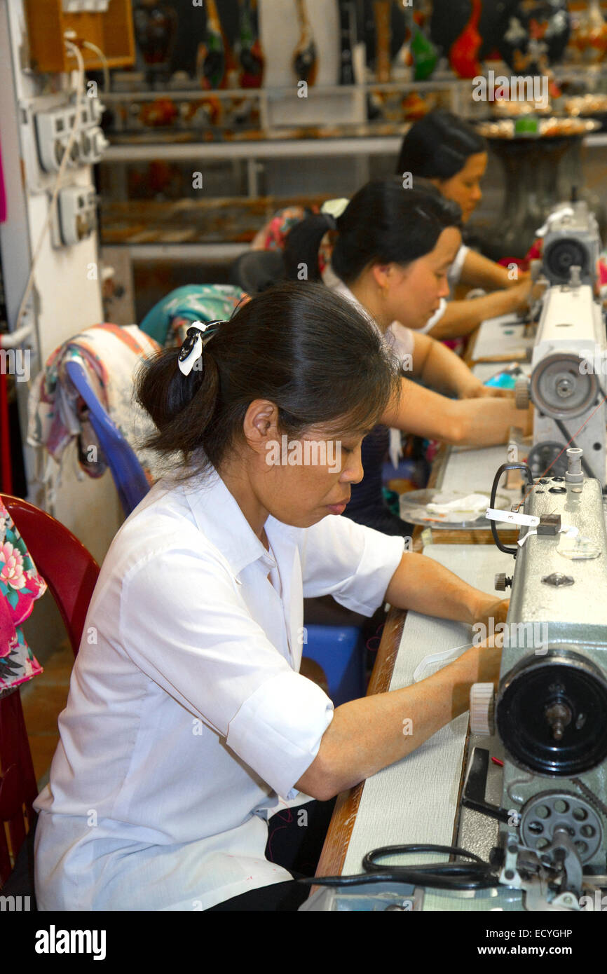 Workers using sewing machines at a clothing factory in Hanoi, Vietnam. Stock Photo