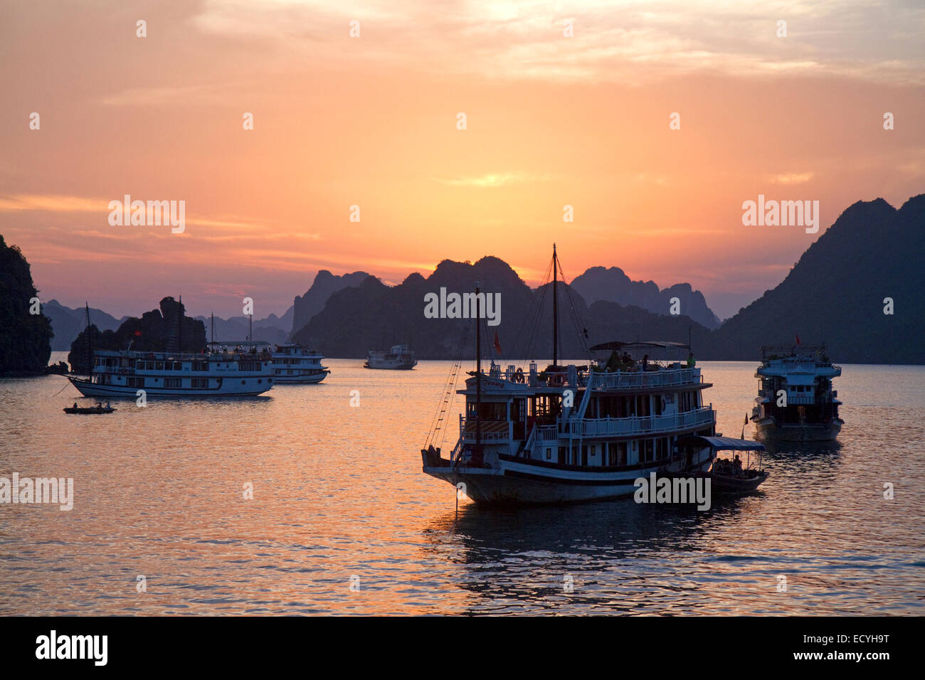 Tour boats at sunset in Ha Long Bay, Vietnam. Stock Photo