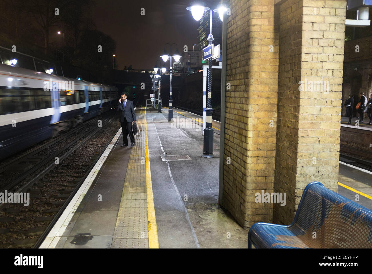 Commuter waiting for Overground train during rush hour at Denmark Hill station,  London, UK. Stock Photo