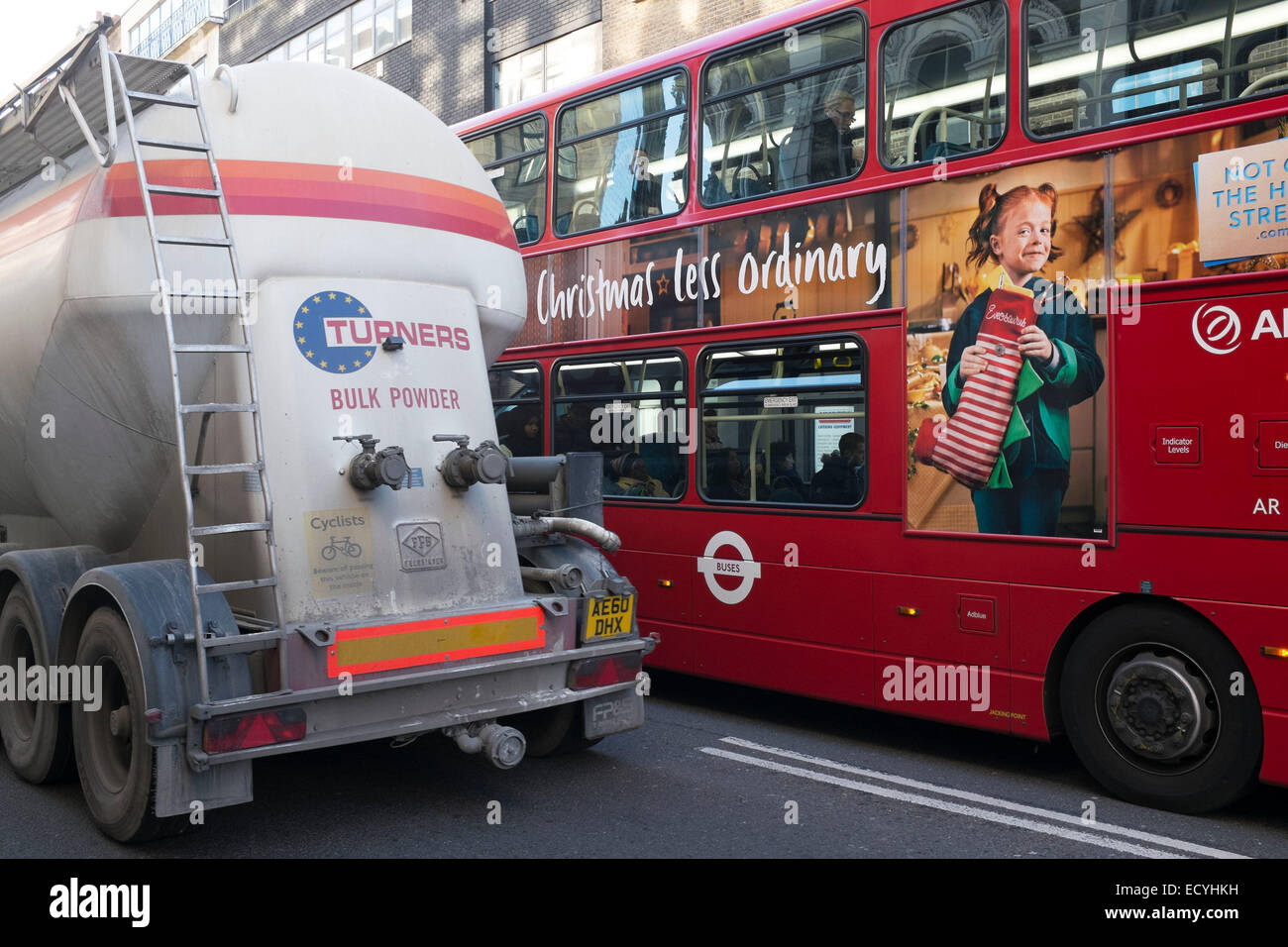 A bus and a cement truck show how large vehicles on the roads of London create a daunting prospect for other road users. UK. Stock Photo