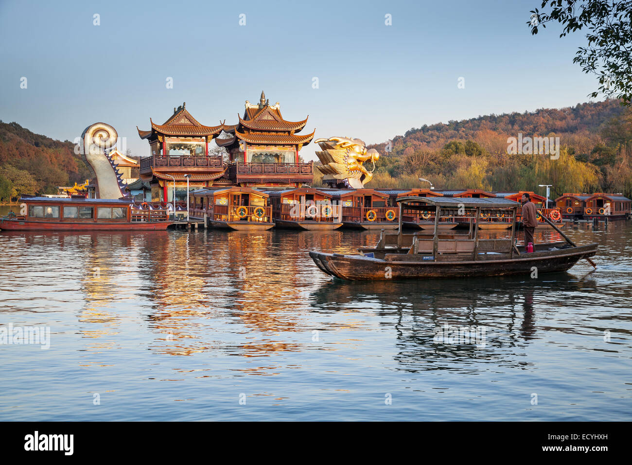 Hangzhou, China - December 5, 2014: Traditional Chinese wooden recreation boat with tourists and boatman floats on the West Lake Stock Photo
