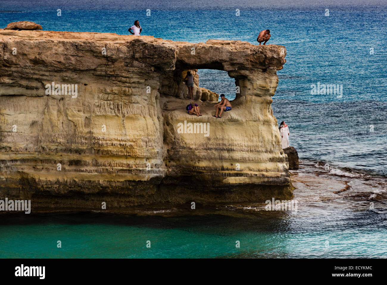 Tourists on the rock cave formations at Cape Greco, Cyprus. Stock Photo