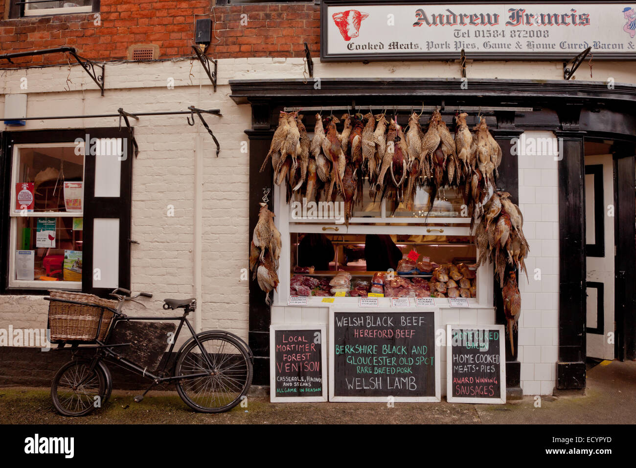 Traditional butchers shop front with game and pheasants hanging up on