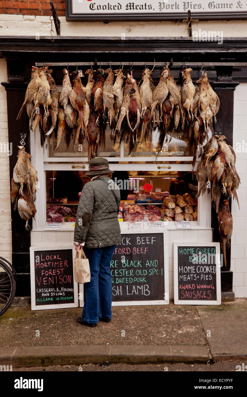 Traditional butchers shop front with game and pheasants hanging up on display, Ludlow, Shropshire UK Stock Photo