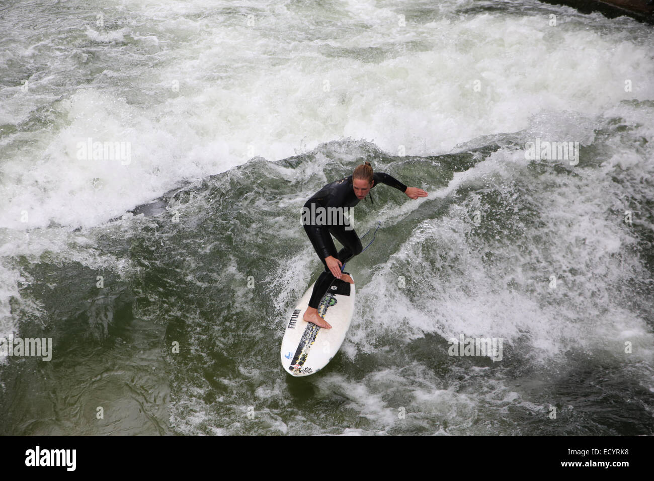 woman surfer surfing man-made wave Eisbach Wave Munich Stock Photo