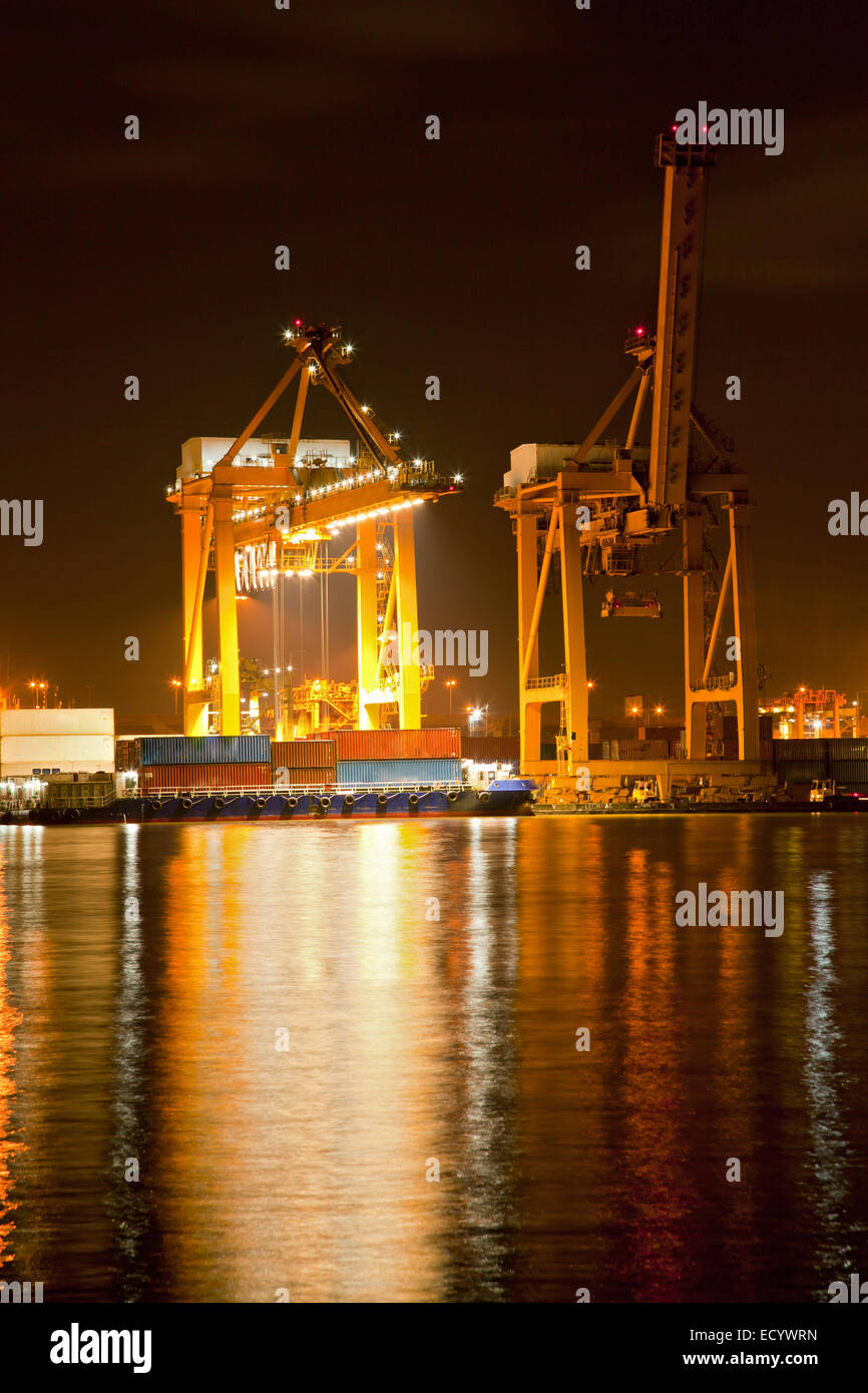 Big Container Cargo ship with working crane in shipyard at dusk ...