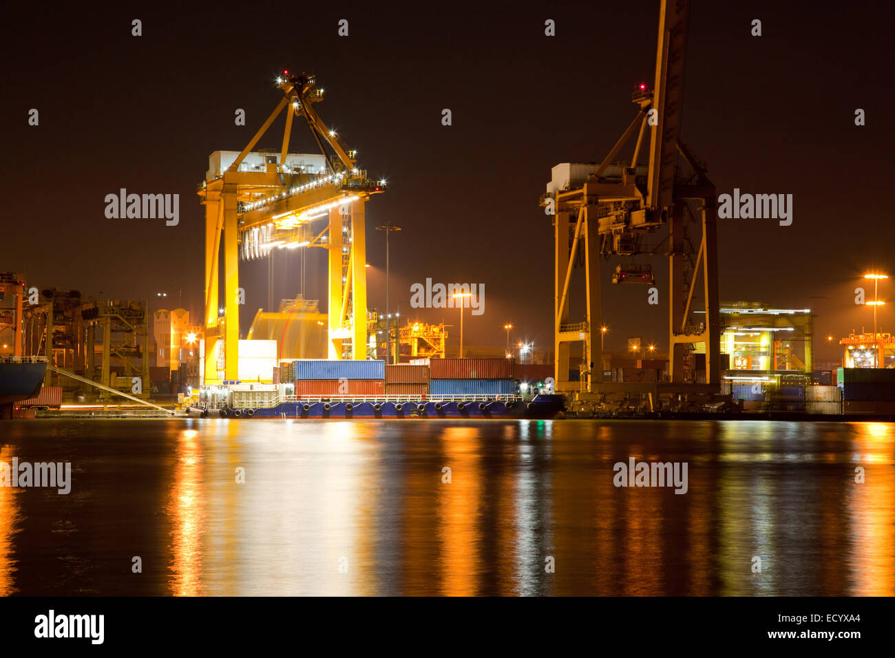 Container Cargo ship with working crane in shipyard at dusk unloading ...