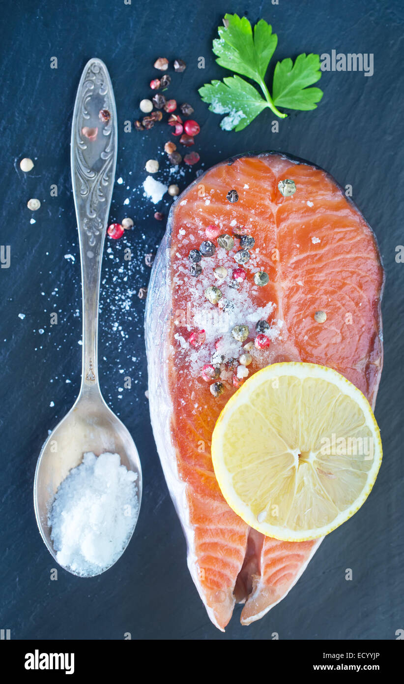 raw salmon steak with spice on the black board Stock Photo - Alamy