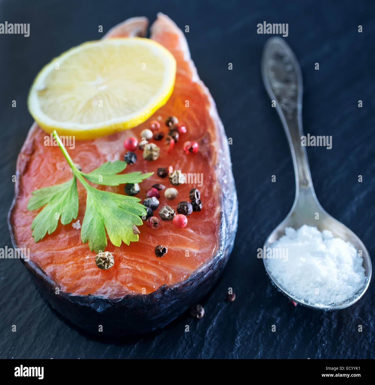 raw salmon steak with spice on the black board Stock Photo - Alamy