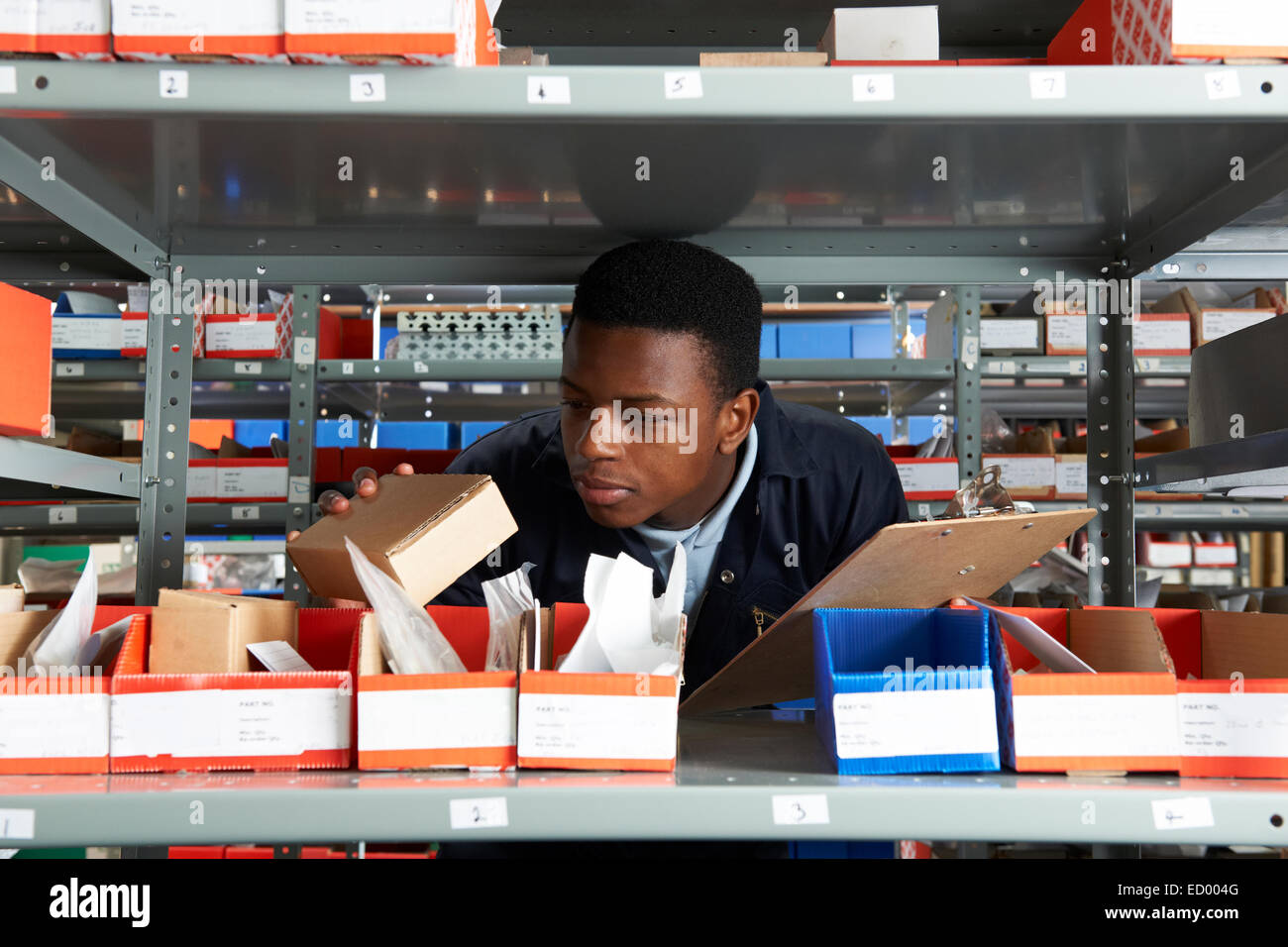 Factory Worker With Clipboard In Storeroom Stock Photo - Alamy