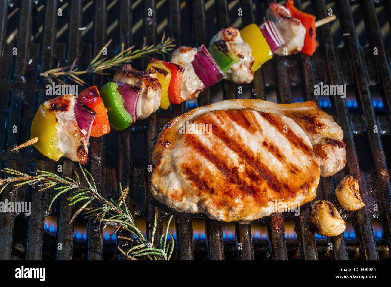 Pork steak and kebabs cooking on a barbecue grill Stock Photo Alamy