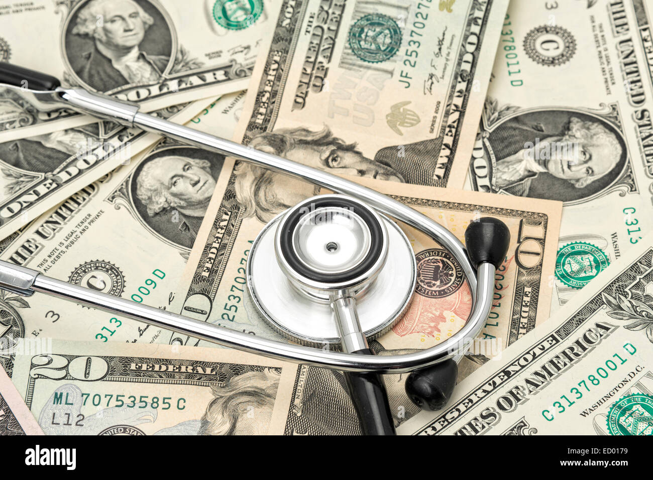 US Dollars under a doctors stethoscope - financial concept.     Studio shot Stock Photo