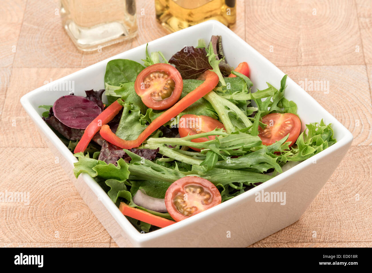 Fresh green salad with tomatoes and red bell peppers - studio shot with a white background Stock Photo