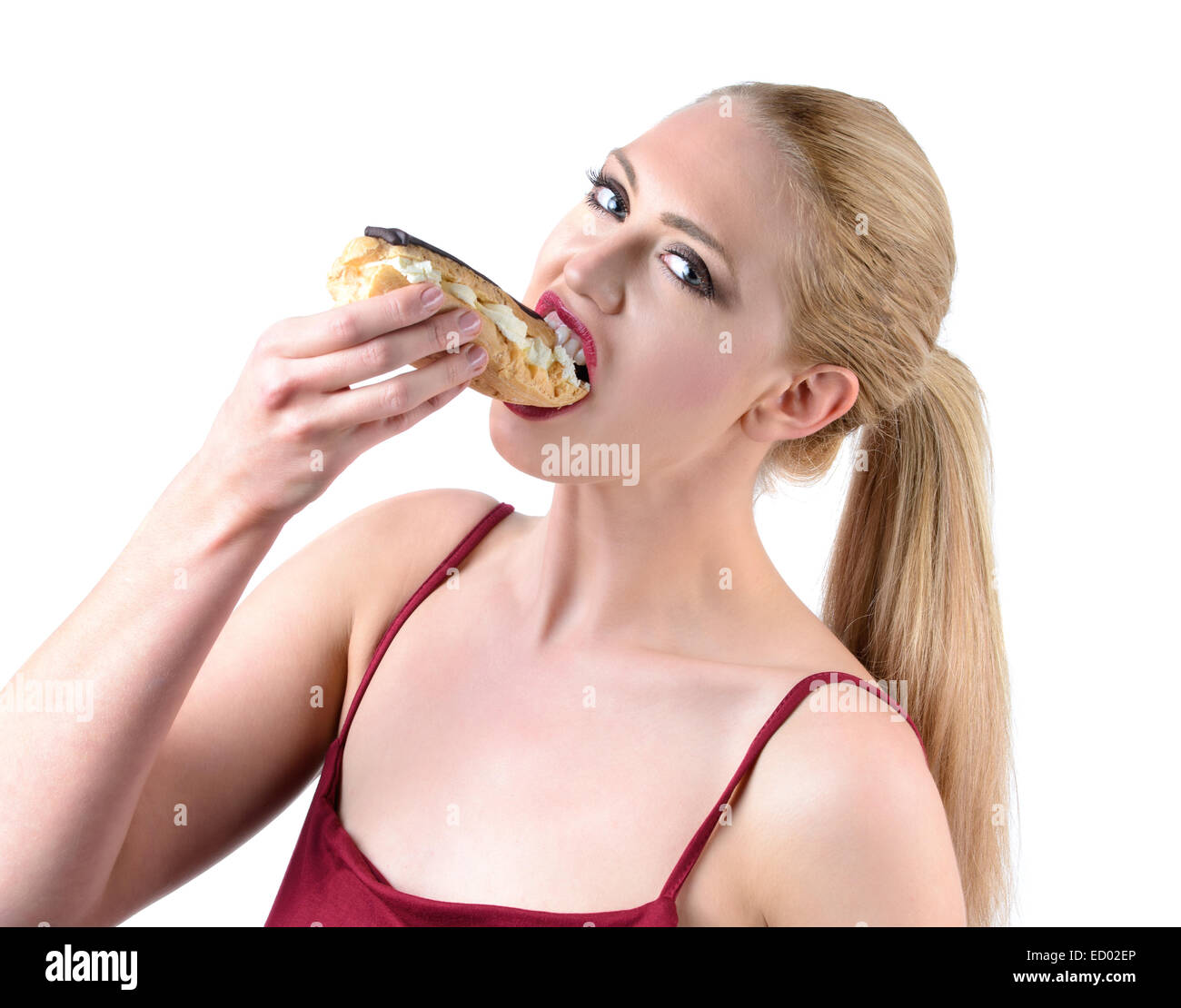 young woman eating a chocolate eclair Stock Photo