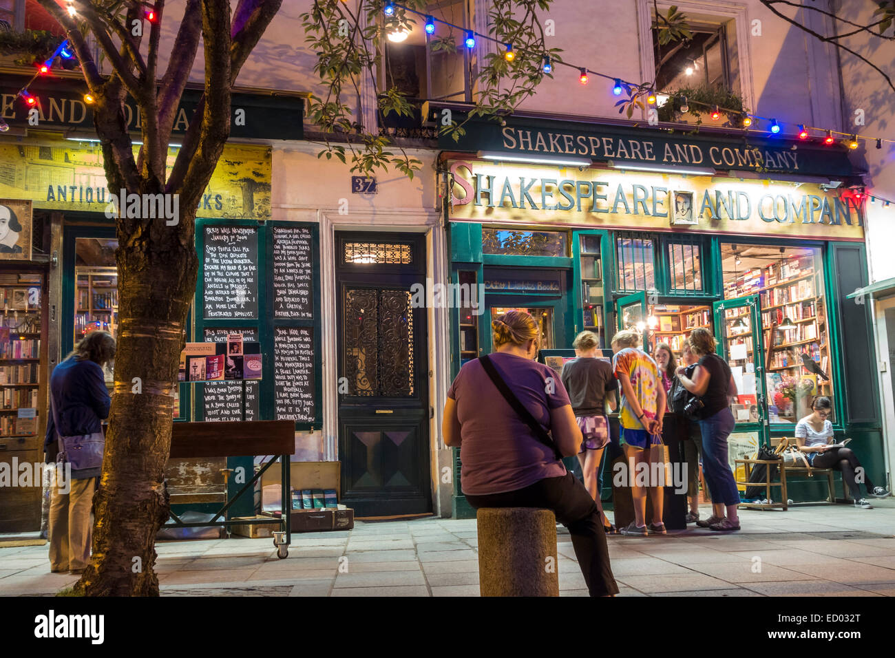 Paris. Young people girls reading, browsing, shopping at famous Shakespeare and Company Paris Bookshop Book Shop Book Store Bookstore Stock Photo