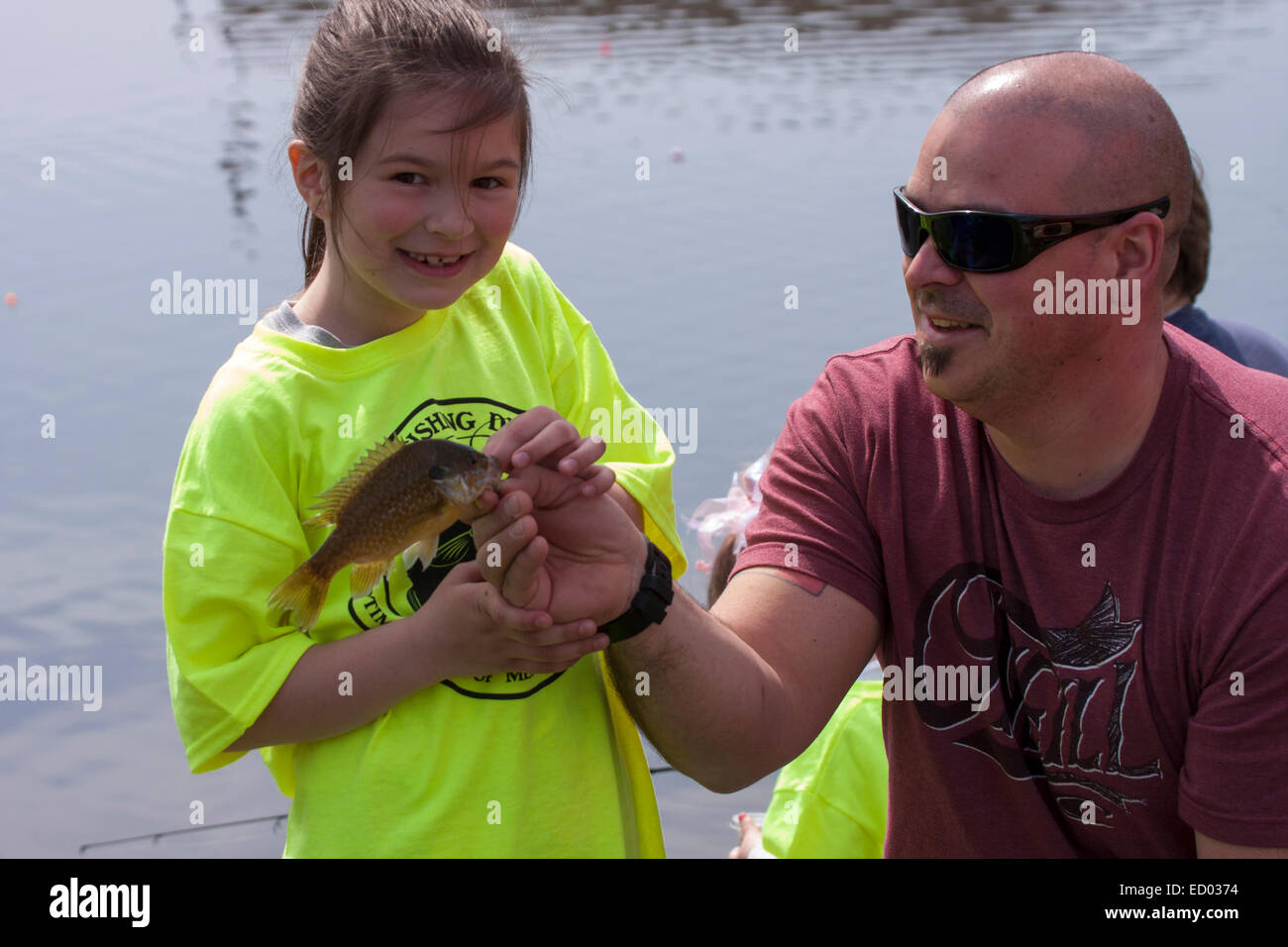 A young girl showing off the fish she caught during a Fishing Derby in