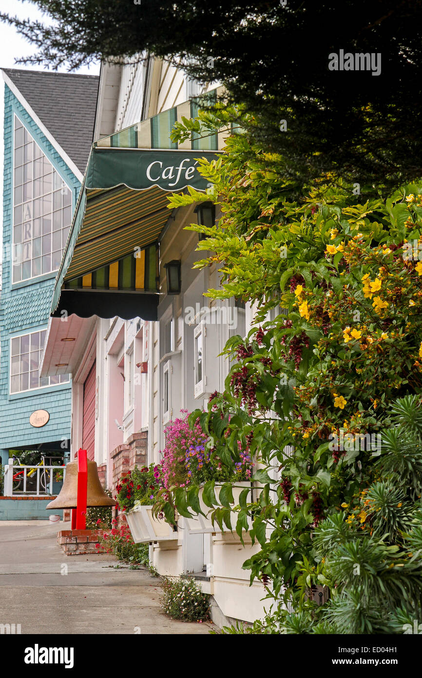 Flowers and colorful shops line the sidewalk in Mendocino, California Stock Photo